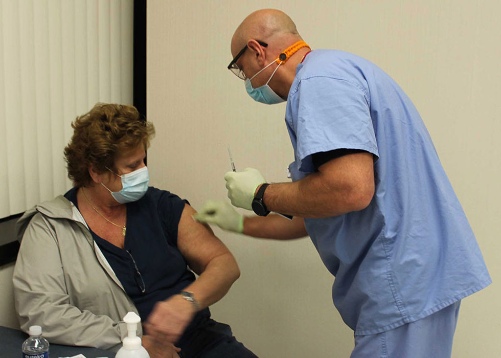 Carol Soltes receives COVID-19 vaccinations from Christopher Coccari, RN